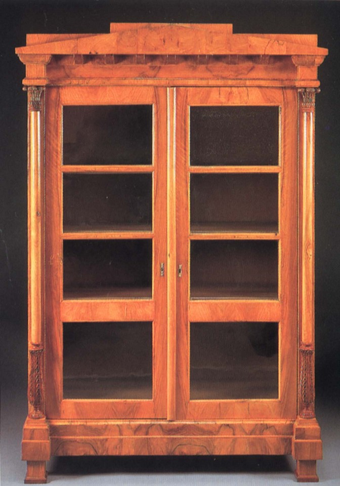 19th Century AUSTRIAN, Biedermeier Black Walnut Bookcase, 1800-1825
Walnut, 78 x 51 5/8 x 20 1/2 in. (198.1 x 131.1 x 52.1 cm)
Peaked pediment and dentiled dornice above a pair of glazed cupboard doors opening to shelves flanked by collumnar supportw with acanthus-carved capitals and terminal raised on block feet
BIE-004-FU