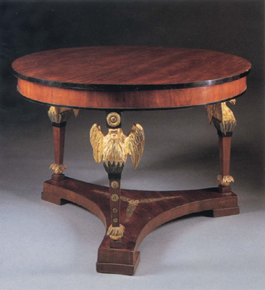 19th Century AUSTRIAN, Neoclassical Mahogany and Parcel Gilt Center Table, 1800-1825
Mixed woods, 29 x 43 x 43 in. (73.7 x 109.2 x 109.2 cm)
Circular top with an ebonized border above the plain frieze, raised on winged eagle terminal supports joined by a tripartite stretcher with later ormolu decoration, all on block feet.
AUS-001-FU